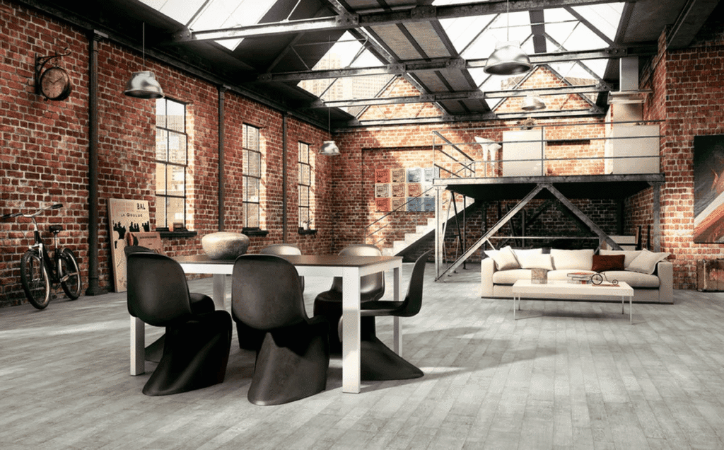 Raw Industrial interior design styles featuring exposed brick walls, metal piping details, and reclaimed wood furniture